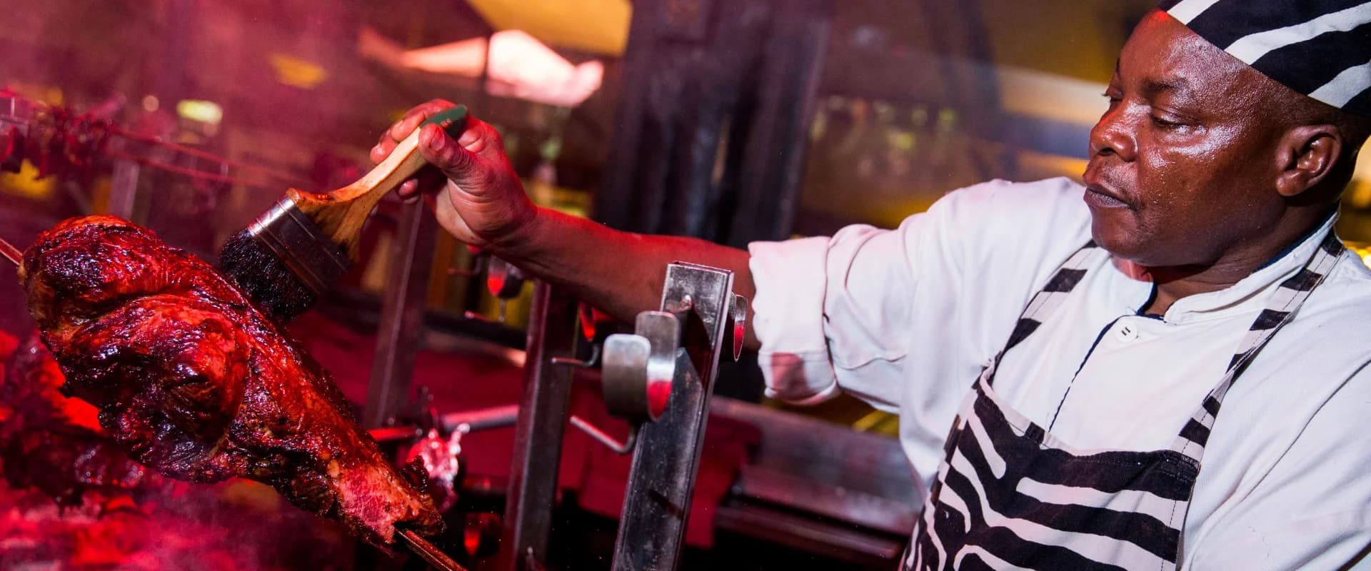 A chef preparing grilled food at Carnivore Restaurant