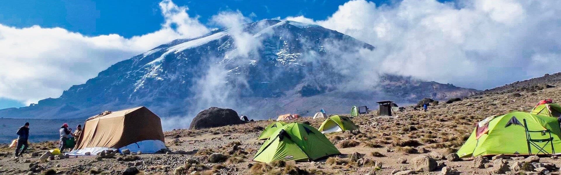 Tents pitched on bare rock at a high camp on Kilimanjaro