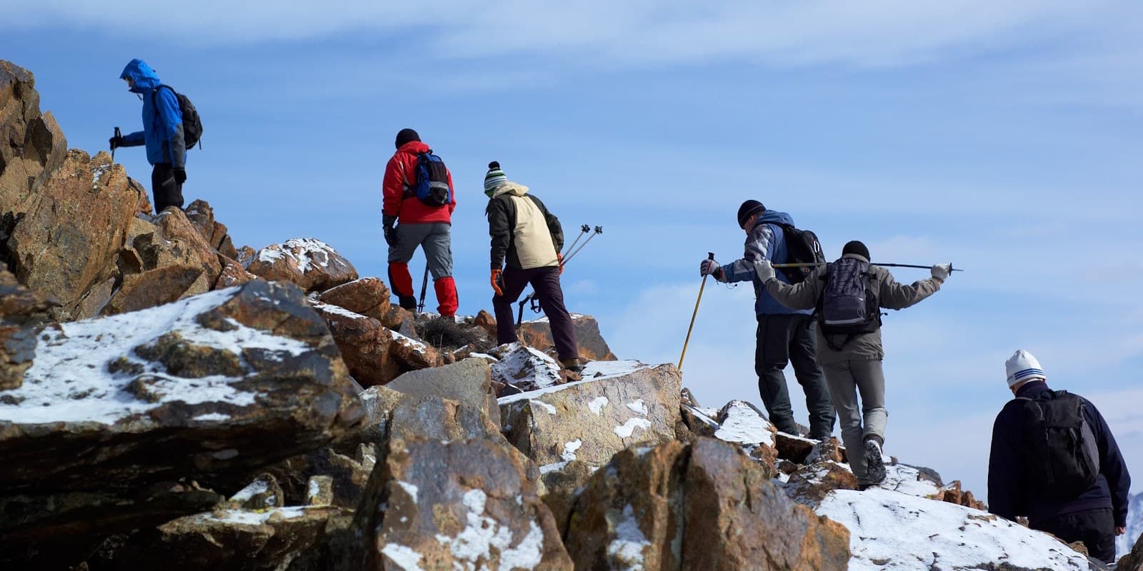 Climbers moving across rock and snow high on Mount Kenya