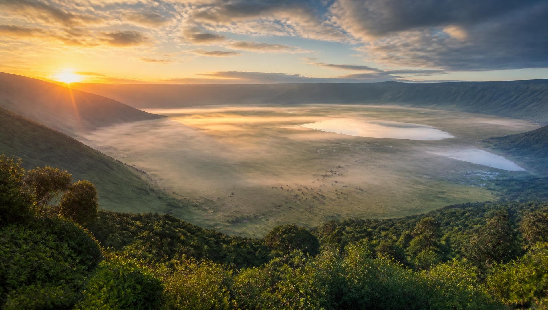 Sunrise over the Ngorongoro Crater rim with the crater floor below